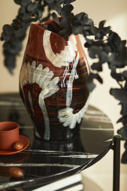 Süslü bir iç mekan, mermer kahve masası, vazoda okaliptüs çiçeği ve modern ev dekorunda bir fincan kahve. Ayrıntılar. Şablon.