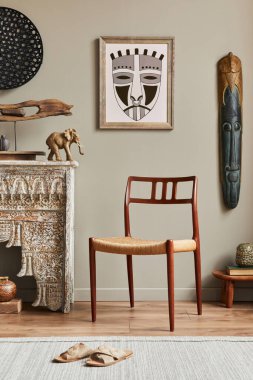 Poster çerçevesi, tasarım koltuğu, raf, dekorasyon, halı ve şık ev dekorasyonlarıyla süslü bir oturma odası. Şablon.