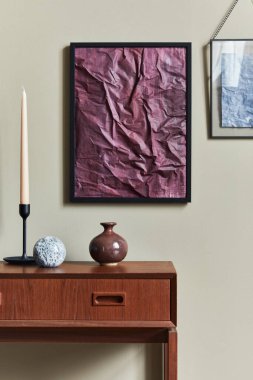 Oturma odasında ahşap retro tuvaletli şık kompozisyon, siyah poster çerçevesi, şamdan, vazo ve ev dekorunda zarif kişisel aksesuarlar. Şablon.