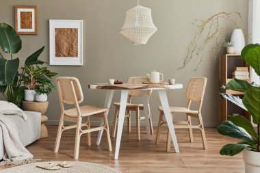 Konforlu evdeki yemek odasının şık iç dekorasyonu beyaz poster çerçevesi, tasarım koltukları, aile masası çaydanlık, fincanlar, dekorasyon ve modern ev dekorasyonundaki zarif kişisel aksesuarlarla. Şablon.