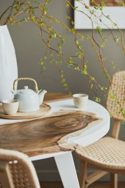 Şık yemek odasının iç tasarımı aile ahşap ve epoksi masa, rattan sandalyeler, vazoda çiçekler ve fincanlı çaydanlık. Ayrıntılar. Şablon.