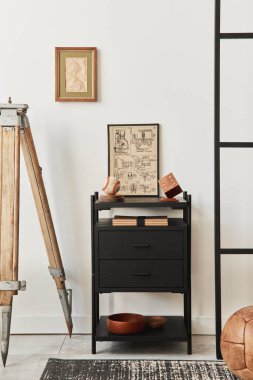 Kahverengi ahşap kaplamalı oturma odasının şık kompozitosu poster çerçevesi, kitap, siyah raf, dekorasyon ve zarif aksesuarlar. Şablon. Beyaz Duvar.