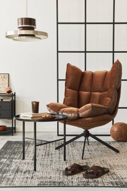 Modern oturma odasının tasarımı kahverengi koltuk, yan masa, pendatn lamba, çatı katı duvarı, terlikler, halı, dekorasyon ve ev dekorasyonunda zarif kişisel aksesuarlar. Şablon. 