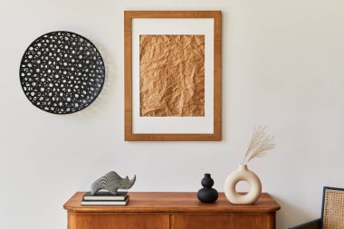 Kahverengi resim çerçevesi, bitki, retro koltuk, kurumuş tropikal yaprak, dekorasyon ve şık ev dekorasyonuyla süslenmiş kişisel aksesuarları olan minimalist oturma odası kompozisyonu. Şablon.