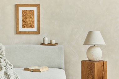 Poster çerçevesi, gri zarif kanepe, ahşap küp, zarif lamba ve kişisel aksesuarlarla dekore edilmiş modern oturma odası kompozisyonu. Tarafsız renkler. Şablon. 