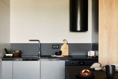 Modern küçük mutfak içinin şık bir kompozisyonu. Siyah mutfak çalışma alanı, siyah ve açık renk ahşap mutfak aksesuarları. Tahta panel yaratıcı duvarlar. Minimalist erkeksi kavram. Şablon.