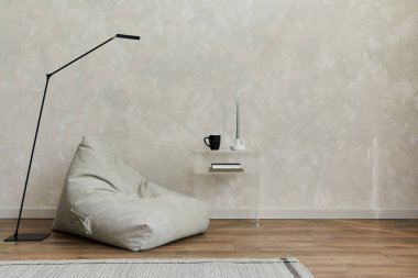 Pouf, sınıf sehpası, halı, lamba, siyah tasarım vazo ve küçük kişisel aksesuarları olan modern lüks oturma odasının yaratıcı kompozisyonu. Yaratıcı duvar ve parke zemin. Minimalist bir kavram. Uzayı kopyala Şablon.