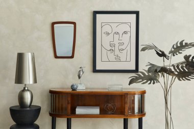 Afiş çerçevesi, ahşap klozet, gümüş modern lamba, ayna, palmiye ve zarif kişisel aksesuarlarla dekore edilmiş yaratıcı bir oturma odası kompozisyonu. Tarafsız bej duvar. Şablon