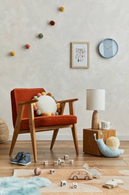 İskandinav çocuk odasının iç kısmının yaratıcı kompozisyonu poster çerçevesi, kırmızı koltuk, peluş oyuncaklar ve asılı süslemelerle. Yaratıcı duvar. Şablon.