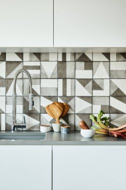 Modern dairede, ahşap mutfak aksesuarları ve çalışma alanı olan şık bir mutfak tasarımı. Yaratıcı duvarlar. Minimalist tarz ve bitki aşkı konsepti. Ayrıntılar.