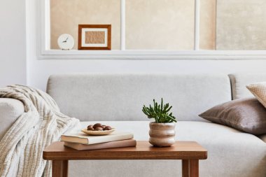 Moda ve rahat oturma odasının yaratıcı kompozisyonu poster çerçevesi, gri kanepe, ahşap sehpa ve kişisel aksesuarlar. Bej nötr renkler. Şablon.