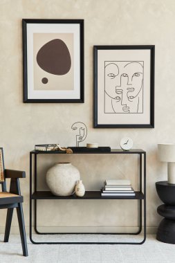 Moda modern oturma odasının yaratıcı kompozisyonu. İki tane poster çerçevesi, siyah geometrik tuvalet, koltuk, kahve masası ve kişisel aksesuarlar. Tarafsız renkler. Şablon.