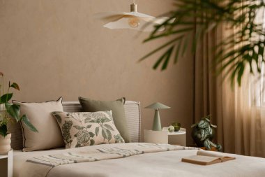 Yumuşak ışıklandırılmış yatak odası köşesi süslemeli lamba ve sakin bir ortamda nötr tonlu yatak..