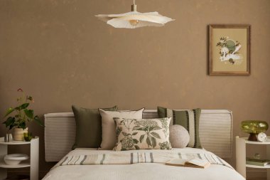 Soyut sanat, yeşil aksanlar ve sakinleştirici bir his için katmanlı doğal tekstil içeren zarif bir yatak odası. Modern ev dekorasyonu.