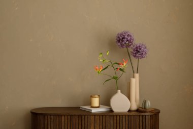 Doğal dokular ve çiçekli vazolar toprak tonlu bir duvara karşı şekillendirilmiş. İnce bir kontrast ve görsel sakinlik. Boşluğu kopyala.