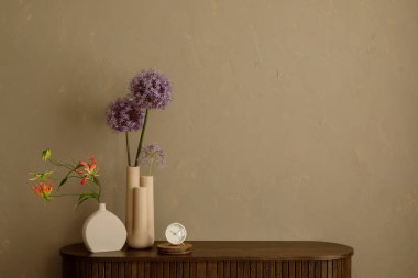Mor alyumlu minimalist çiçek aranjmanı ve koyu ahşap bir büfede seramik vazolarda turuncu ihtişam. Boşluğu kopyala. 