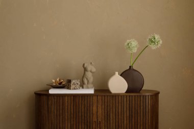 Heykel desenli minimalist büfe, seramik vazolar ve desenli bej bir duvara karşı beyaz Allison çiçekleri. Boşluğu kopyala.