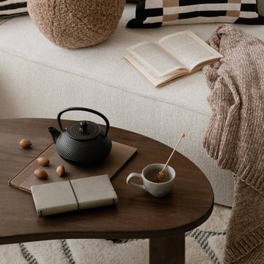 Sehpayı kapat. Parlak yaşam alanı, ahşap döşeme ve örülmüş mobilyalar. Doğal dokular ve hafif ışıklandırma dengesi..