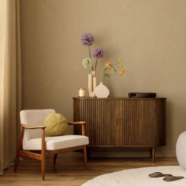 Ahşap büfesi, koltuğu ve tarafsız tonlarda modern çiçek düzenlemeleri olan rahat bir oturma odası. Duvardaki sanat eserleri. 