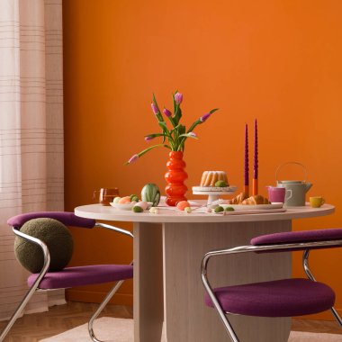 Turuncu duvarlı modern bir iç mekanda laleler, mumlar ve bahar ikramlarıyla renkli Paskalya düzenlemeleri..