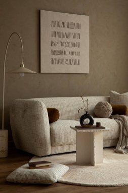 İç tarafında bir kanepe, masa dekorasyonu ve bej duvarlar var. Sıcak, nötr bir renk paleti. Yaşam tarzı, ev dekorasyonu, huzur ve rahatlama için kullanılıyor.