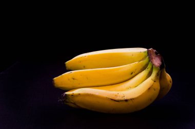 Kırpma yolu ve tüm alan derinliği ile siyah arkaplan izole muz bir grup.