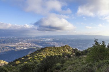Montserrat dağlarının güzel bir bahar günü havadan görünüşü, Katalonya, İspanya. Dağların üzerinde dramatik bir gökyüzü. Güneş ışığı bulutların arasından düşer yeryüzüne ve dağlara.