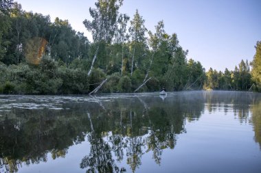 Bir adam gölde bir kanoyla yelken açıyor. kano.