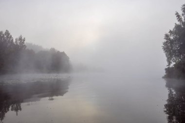 Sabah erkenden. Nehirde sis var. Yazın nehrin kenarında güzel bir gün doğumu. Nehirde gizemli bir sabah