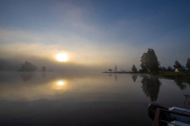 Tepenin üzerinde günbatımının canlı renkleri. Akşamları renkli manzara, tepeli bir tarlanın üzerinde altın bulutlarla muhteşem mavi gökyüzü..