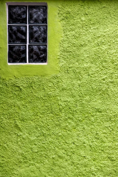 Glass brick window on green textured wall
