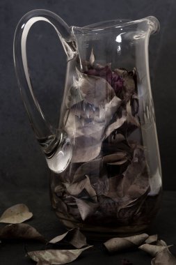 Koyu arkaplanda kurumuş aromatik yapraklı cam kavanozu kapat..