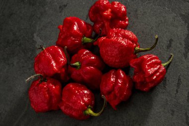 Koyu arkaplanda Habanero biberleri, kırsal masada olgun kırmızı biberler, acı habanero biberleri. Metin için boşluk