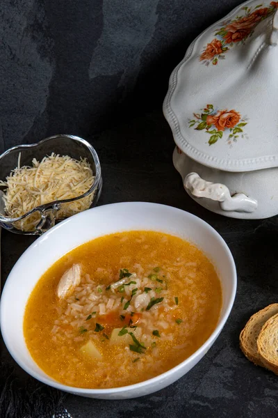 Brazilian cuisine - Chicken soup or Canja de galinha in portuguese - Traditional Brazil dishes, soup with chicken and rice served on decorated antique soup bowl from the 19th century