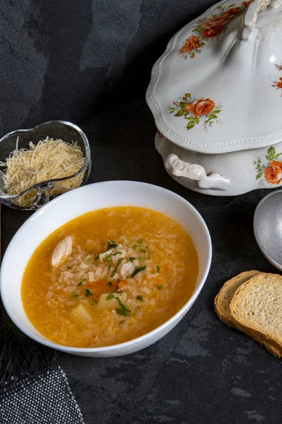 Brazilian cuisine - Chicken soup or Canja de galinha in portuguese - Traditional Brazil dishes, soup with chicken and rice served on decorated antique soup bowl from the 19th century