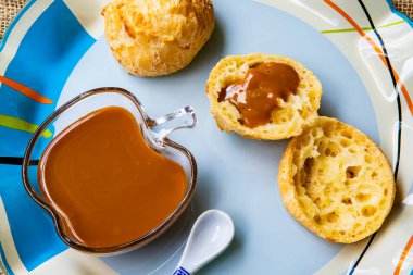 Portekizce 'de Brezilya peynirli ekmek ya da pao de queijo, renkli bir tabakta kremalı dulce de leche ile doldurulmuş. Gurme peynirli ekmek, Minas Gerais Eyaleti geleneği, Brezilya