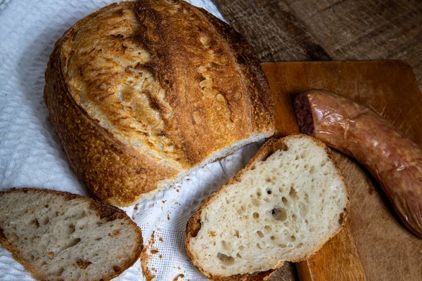 自制的食物 美味的天然发酵面包与典型的蓝面香肠 在白布餐巾和木制桌子上 — 图库照片