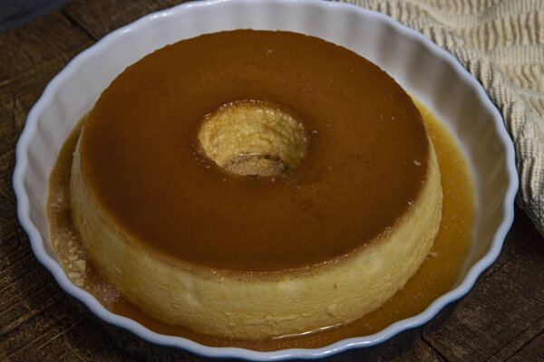 Молочный пудинг или Pudim de leite. Бразильский десерт домашний карамельный пудинг. Традиционный бразильский пирог на деревянном фоне