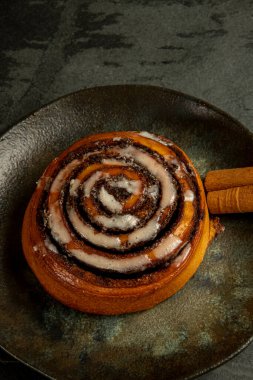 Baharatlı taze tarçınlı ekmek ve tarçın çubuğuyla süslenmiş kırsal tabakta kakao. Üst manzara. Ev yapımı tatlı Noel pastası. Kapatın. Kanelbule - İsveç tatlısı.