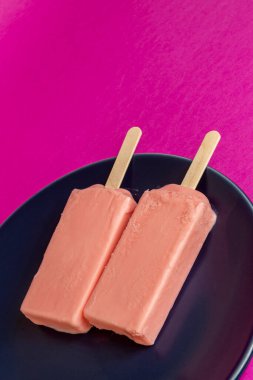 Mavi tabak ve fuşya arka planında eriyen böğürtlen dondurması. Uzay metni