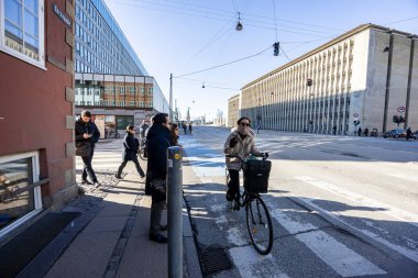 Bisiklet yolunda bisiklet süren insanlar. Kopenhag 'da şehir caddesinde bisiklet trafiği. Danimarka 'da sürdürülebilir ulaşım ve modern şehir hayatı kavramı. Kopenhag, Danimarka - 31 Mart 2025