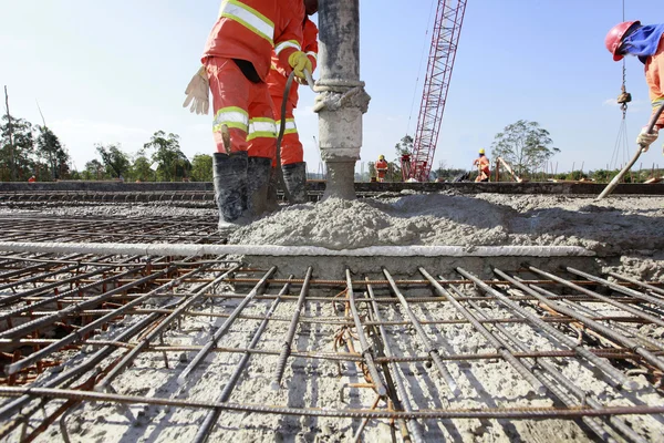 workers pouring cement in road construction on brazil