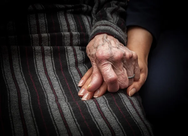 Aged hand holding young hand — Stock Photo, Image