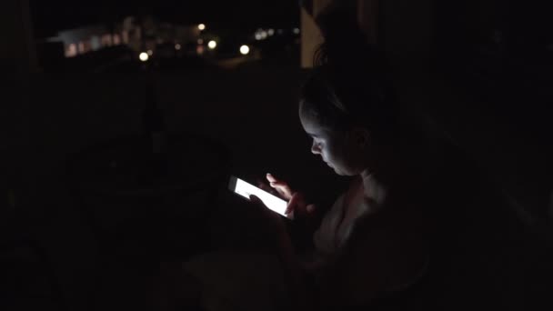 Девушка прокручивает свою временную линию в телефоне ночью. Барышня рыскает по интернету ночью. — стоковое видео