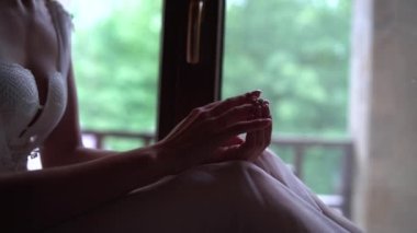 Nikah yüzüğüyle gelinin yakın çekimi. Gelinlikli genç bayan nişan yüzüğünü takıyor. Yumuşak parmaklar ve güzel çizgiler.