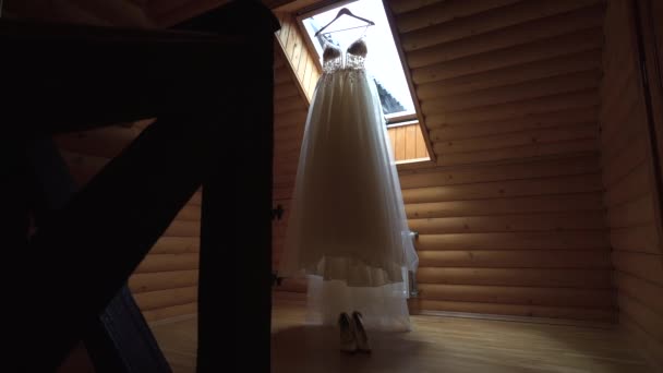 Largo tiro de hermoso vestido de novia. Traje de novias colgando elegantemente. Vestido blanco esperando a su novia. — Vídeo de stock