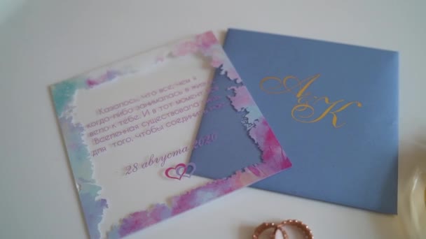 Close shot of wedding details. Beautiful rings, invitations and parfumes. Things for wedding in tender colors. — Stock Video