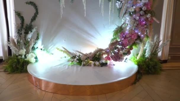 美しく装飾されたフォトゾーンの長いショット。花と光の多くの大きなスタンド。あなたの特別な日のための素晴らしい花の組成. — ストック動画