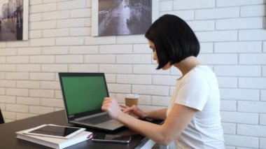 Laptopunda siyah saçlı genç bir bayan daktilo ediyor. Kadın internet sitelerine göz atmak, online alışveriş yapmak, sipariş vermek. İnternette çalışan ve kahve içen genç bir yetişkin.. 