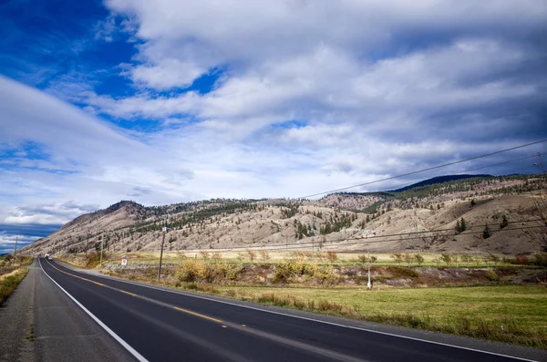 Boş asfalt karayolu aracılığıyla dağlık ülkenin